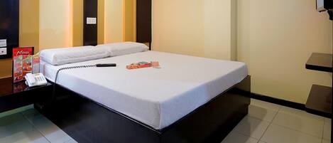 Una habitación de hotel con cama, teléfono, revista y cartel de menú.