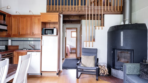 A compact living space with a kitchen, dining area, and a fireplace. - Tahkon klubitie 2 b by Interhome (Nilsiä)