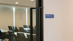 Ein Besprechungsraum mit einem Schild, das angibt, dass es sich um Besprechungsraum 1 handelt.