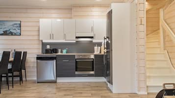 Een koelkast, een magnetron, een vaatwasser, kookgerei, borden en bestek