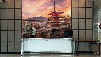 A reception desk with a backdrop of a traditional Japanese pagoda and cherry blossoms.