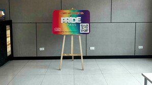 Ein Raum mit einem großen Schild auf einem Ständer, einem Deckenprojektor und einem Fliesenboden.