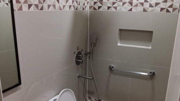Een kleine badkamer met toilet, wastafel en douche.