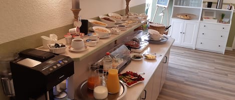 A breakfast buffet with various food items and a coffee machine.