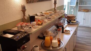Ein Frühstücksbuffet mit verschiedenen Speisen, einer Kaffeemaschine und einem Schild mit der Aufschrift 'Shorthand Buffet'.