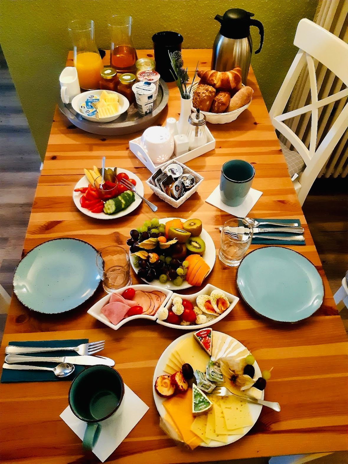 Monipuolinen aamiaisbuffet, jossa on tarjolla erilaisia ruokia ja ruokailuvälineitä.