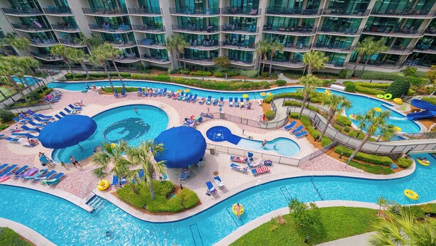Een hotel met meerdere verdiepingen, een groot binnenzwembad, diverse lounges en een waterglijbaan.