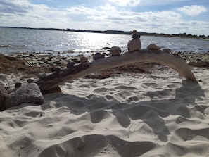 A sandy beach with a wooden structure and rocks. - Doppelzimmer 28 - Strandhaus Mönchgut (Mönchgut)