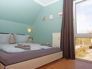 Une chambre à coucher avec un lit, une fenêtre et une vue sur l’extérieur.