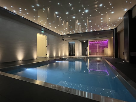 Una piscina techada, sillones reclinables de piscina