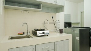 A kitchen with a sink, stove, and refrigerator. - Cozy with River View @ 2BR Teluk Intan Apartment (Jakarta)