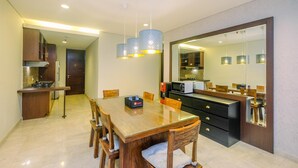 Una cocina moderna con comedor, que incluye una mesa de madera, sillas e iluminación colgante.