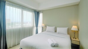 Ein Hotelzimmer mit einem großen Bett, zwei Nachttischlampen und Blick aus dem Fenster.