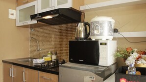 Une cuisine compacte équipée d’un four à micro-ondes, d’une bouilloire et d’un réfrigérateur.