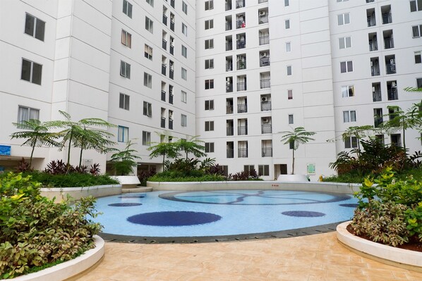 Um pátio com piscina, rodeado por edifícios residenciais altos.