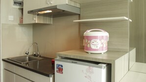A kitchen with a stainless steel sink, a built-in oven, and a pink appliance on the countertop.