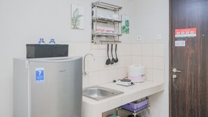 Eine kleine Küchenzeile mit Kühlschrank, Spüle und einer Arbeitsfläche.