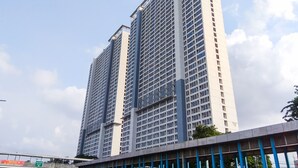 Un edificio de gran altura con un diseño arquitectónico moderno, que presenta una cuadrícula de ventanas y una columna central destacada.