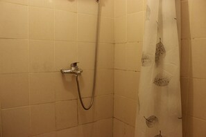 Enjoy a refreshing shower in this shower area with a fixed showerhead and handheld shower attachment.