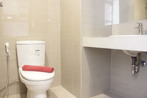A modern bathroom with a toilet, a shower, and a sink. - Spacious Studio Room at Galeri Ciumbuleuit 3 Apartment (Bandung)