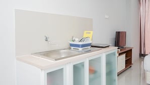 Una cocina moderna con un lavamanos, un escurreplatos y un armario de madera.