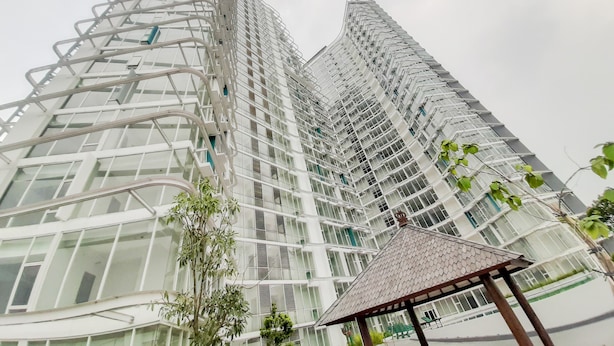 Un moderno edificio de gran altura con un diseño angular único, caracterizado por amplias fachadas de vidrio y un prominente atrio central.