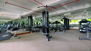 A gym with various exercise equipment, including treadmills and weight machines, arranged in a spacious layout. - Best Location and New Furnished @ Studio Capitol Park Residence Apartment (Jakarta)