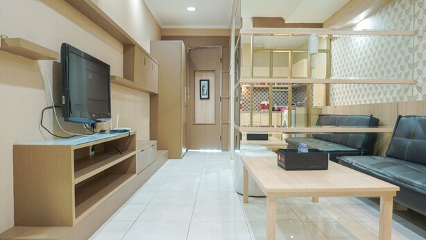 Un salon moderne avec un téléviseur à écran plat, une table basse en bois et un canapé.