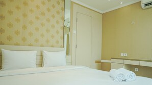 Une chambre d’hôtel avec un lit, des oreillers, un miroir et une serviette sur le lit.