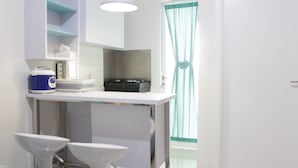 A modern bathroom with a white sink, a mirror, and a towel rack.