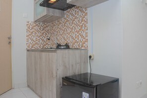 Een koelkast, een kookplaat, een vaatwasser, kookgerei, borden en bestek