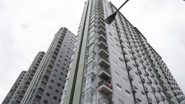 Ein Hochhaus mit mehreren Balkonen und einer Straßenlaterne.