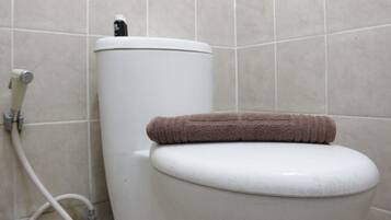 A toilet with a towel on the seat and a water heater on top.