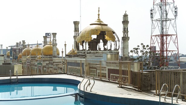 A swimming pool with a view of a mosque with golden domes and minarets. - Compact and Simple Studio Apartment at Saladdin Mansion (Depok)