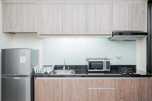 Appartement, niet-roken, kitchenette | Privékitchenette | Een koelkast, een kookplaat, kookgerei, borden en bestek