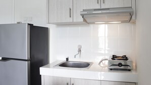 A kitchen with a stainless steel refrigerator, a sink, and a gas stove. - Spacious 3BR Apartment Parahyangan Residence near UNPAR (Bandung)