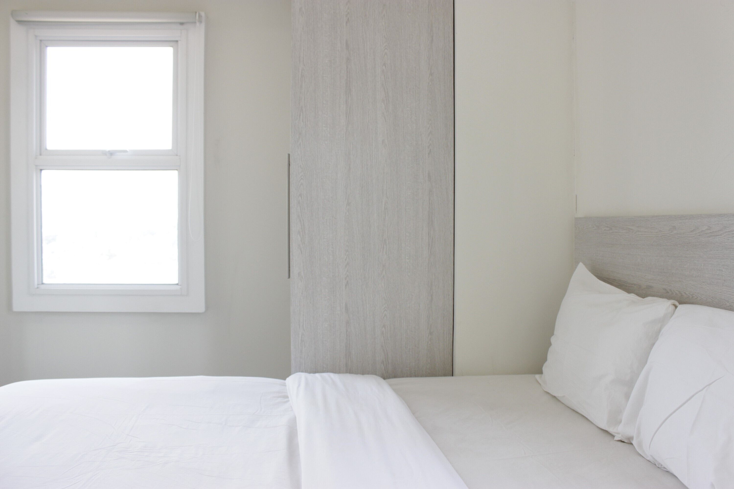 Ein Schlafzimmer mit einem Bett, einem Fenster und einem Holzkopfende.