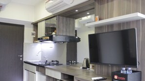 Une cuisine moderne équipée d’un téléviseur à écran plat, d’une machine à café et d’un coffre-fort pour les objets de valeur.