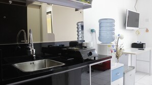 A modern kitchen with a stainless steel sink, a gas stove, and a water dispenser.