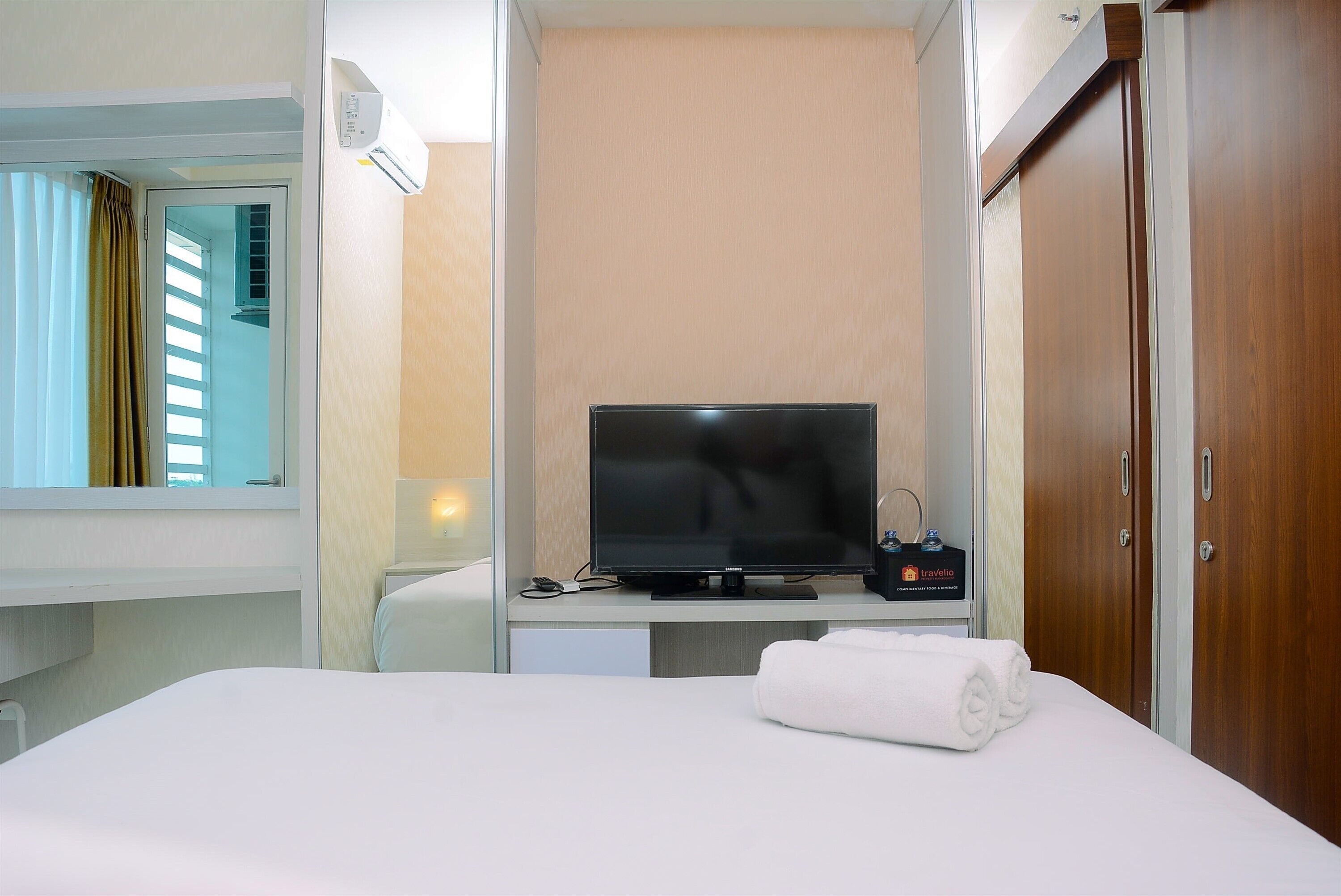 Une chambre d’hôtel équipée d’un lit, d’une télévision, d’un minibar et d’une armoire.