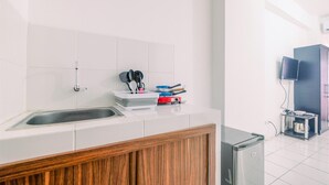 A modern kitchen with a stainless steel sink, wooden cabinets, and a built-in refrigerator.
