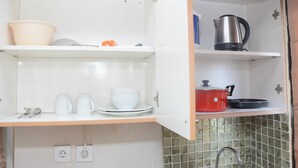A kitchen with white cabinets, a sink, and a tiled backsplash. - Cozy Living with Modern Design 1BR Kebagusan City Apartment (Jakarta)