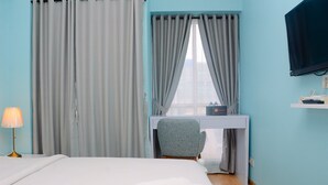 A hotel room with a bed, a desk with a chair, a TV, and curtains. - Relaxing Studio at Tifolia Apartment (Jakarta)