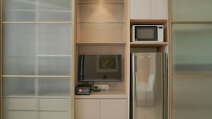 Eine Küchenzeile mit Mikrowelle, Fernseher und Kühlschrank.