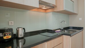 Eine moderne Küche mit schwarzer Arbeitsplatte, Edelstahlgeräten und Holzschränken.