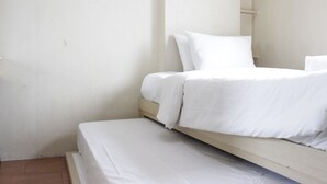 A small, clean room with a single bed and a wooden nightstand. - Private & Stylish 2BR at Gateway Apartment Ahmad Yani Cicadas (Bandung)