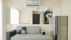 Una sala de estar moderna con un sofá, un refrigerador y un espejo grande.