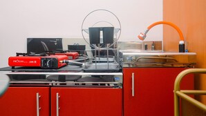 Een keuken met een rode apparatuur, een spoelbak en een slang.