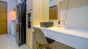 A modern kitchen with a built-in refrigerator, a microwave, and a travel bag on the counter. - Homey and Warm Studio Apartment Oasis Cikarang (Cikarang)