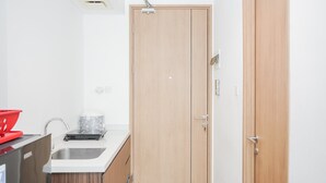 A compact kitchen with a sink, a coffee machine, and a cabinet. - Modern Studio Apartment at Tree Park Cikokol (Tangerang)